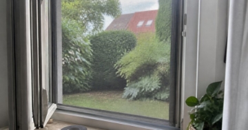Fliegengitter im Aluminiumrahmen an einem geöffneten Fenster