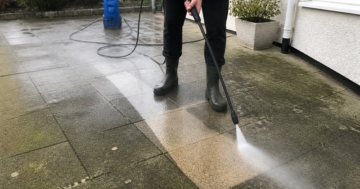 Hochdruckreiniger reinigt Betonplatten auf einer Terrasse